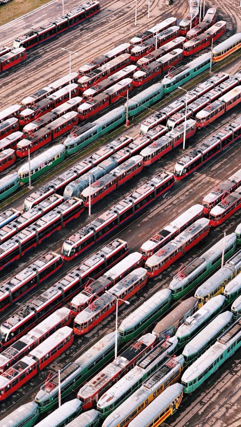 Dense rows of red, green and white trams in a depot yard.