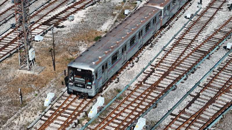 Grey metro train on a curve in a fan of depot tracks.
