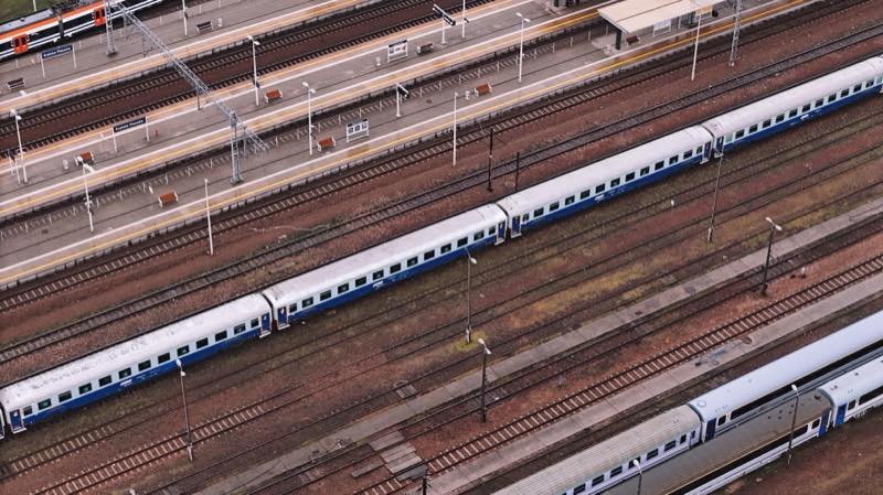 Long blue and white trains stabled in a wide yard, seen from above.