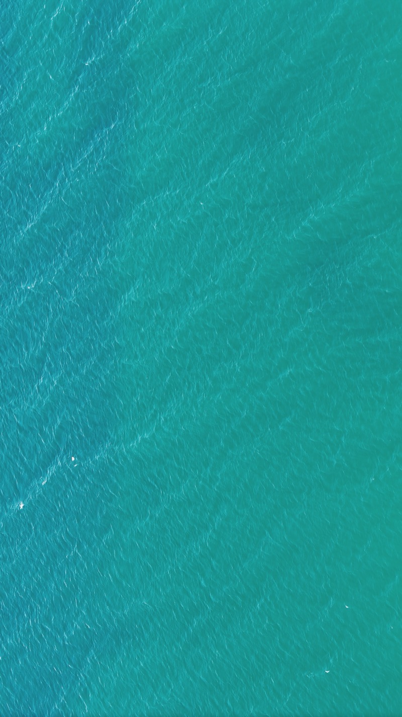 Turquoise sea surface seen straight down from above.