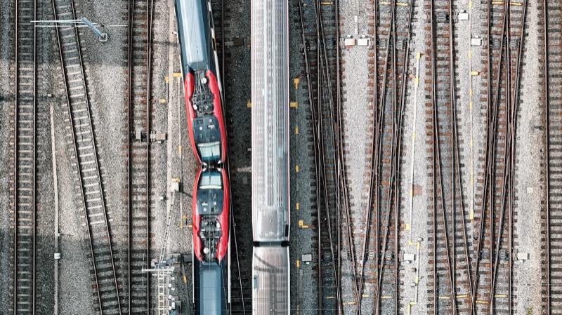 Two red-fronted trains side by side, seen from directly above a rail yard.